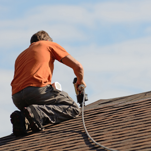 Roofing Contractor in Welland How to Get the Best Value For Your Money - a roofer in an orange shirt working on a roof