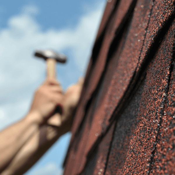 welland roofers - Roof Inspection Why It's Important and How to Do It - hand with a hammer making roof repair